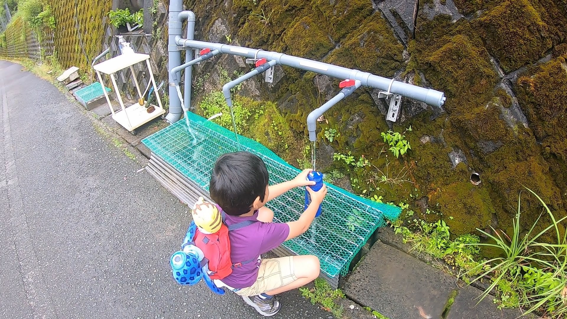 湧き水を汲む子ども